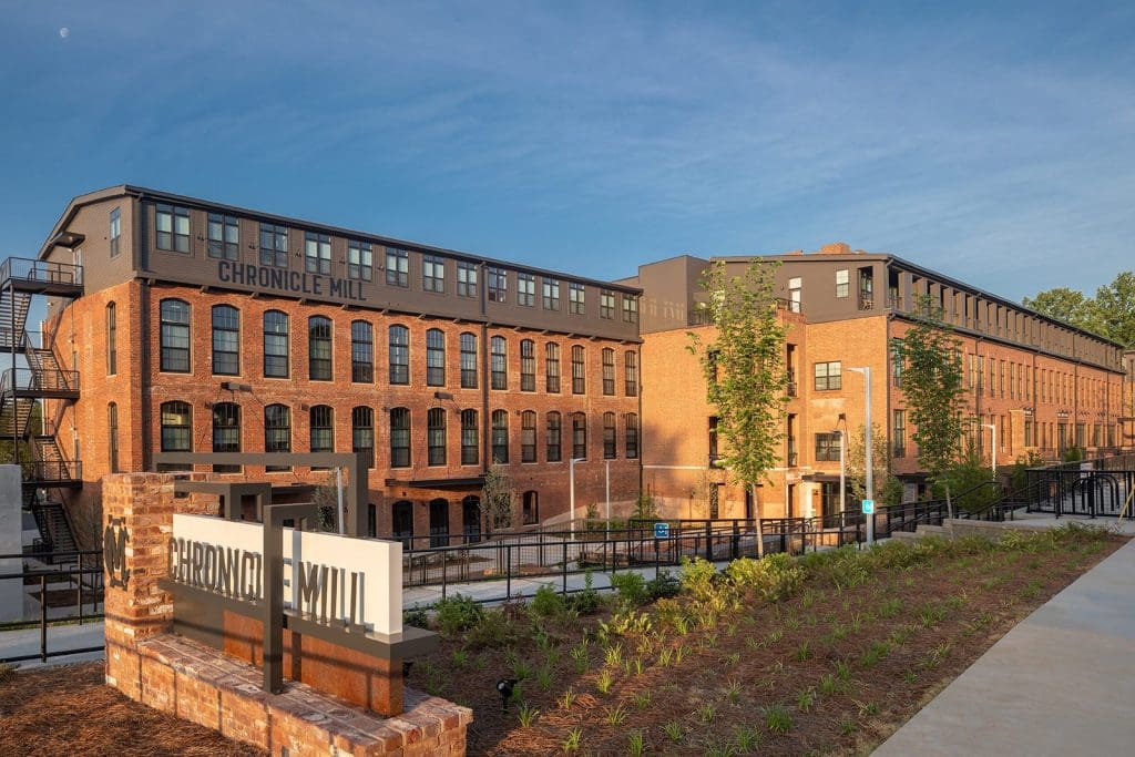 Chronicle Mill in Belmont, the restored red-brick textile mill converted to apartments, seen along its full length.