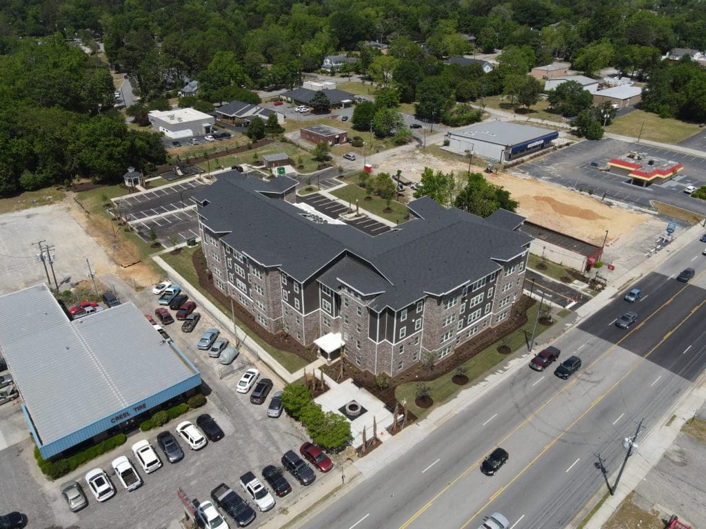 Aerial view of The Belmont in Florence, South Carolina, a large apartment building beside its car park.